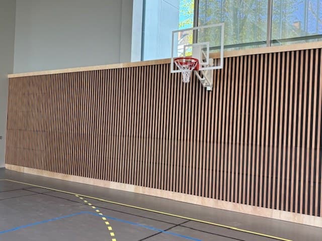 Habillage bois à claire-voie acoustique en partie basse d'un gymnase, salle Delcenserie